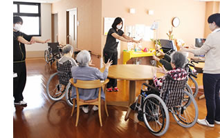 入居者が自転車に乗る機能訓練の様子。スタッフが見守る中で実施されている。